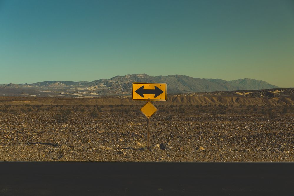 Photo of a sign with an arrow pointing in two directions