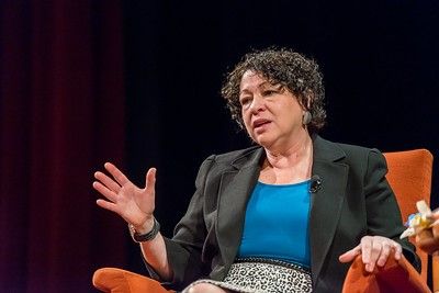 Justice Sonia Sotomayor sitting on a stage, mid-speech.jpg
