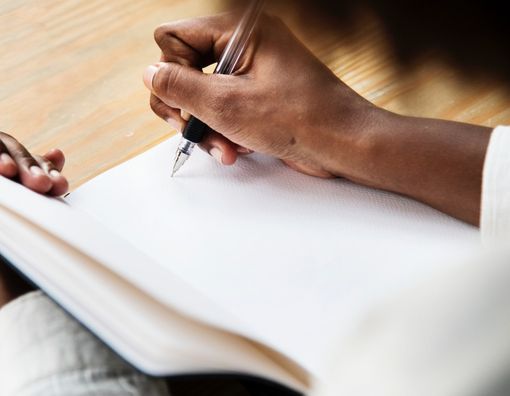 Close-up-of-hand-with-pen-writing-on-paper.jpg