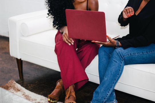 Two-women-sitting-and-looking-at-laptop-together.jpg