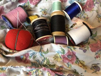 Quilting supplies placed on a white background with multicolored flowers.jpg