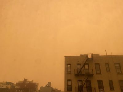 Orange sky over apartment buildings near the East River in NYC at 1:58 pm, June 7, 2023. Photo by Susan Bernstein