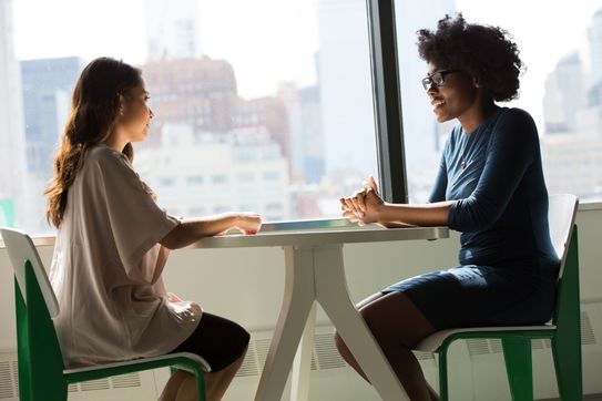 two women sitting at a table chatting.jpg