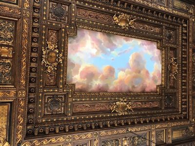 Ceiling at the New York Public Library with a painting of clouds and sky  surrounded by an ornate frame.